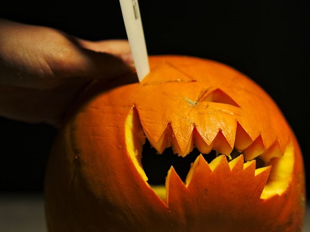a pumpkin being carved as Jack-o-Lantern for Halloween